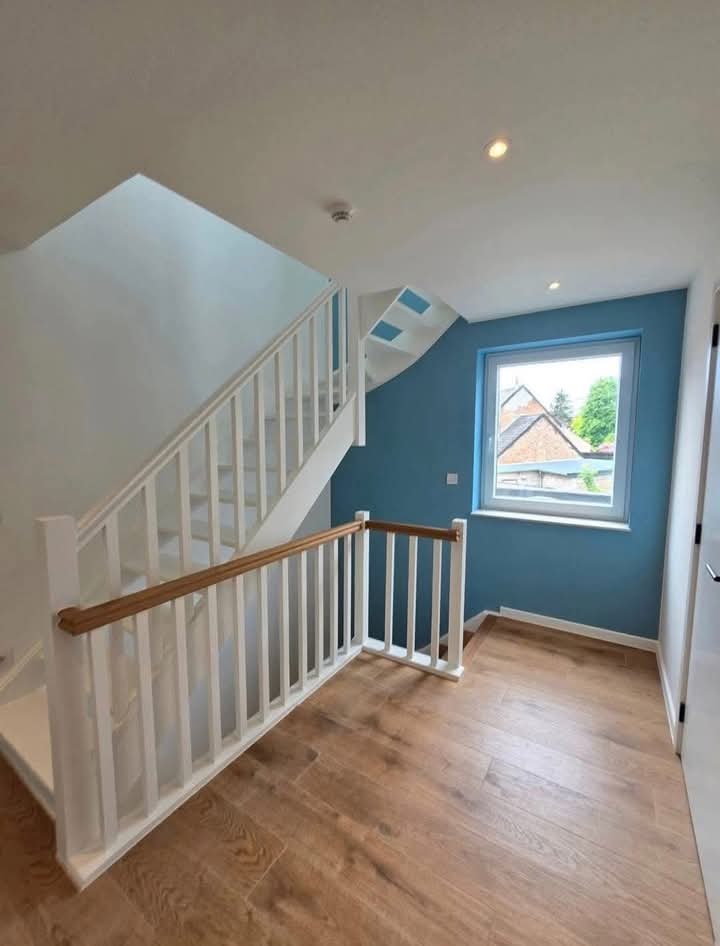 Palier d'étage avec mur bleu et parquet