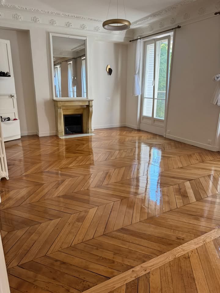 Salon avec cheminée et parquet chevron
